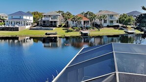 A residential area with houses along a calm water body, a dock, and a boat.