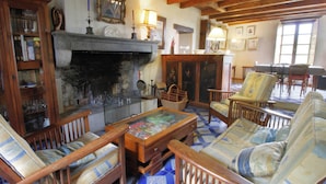 Un salón tradicional con chimenea, muebles de madera y suelo estampado.