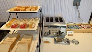 A breakfast buffet with various pastries, sandwiches, and packaged snacks. - Homeinn Plus Hotel (Qingdao Weihai Road Taidong Pedestrian Street) (Qingdao)