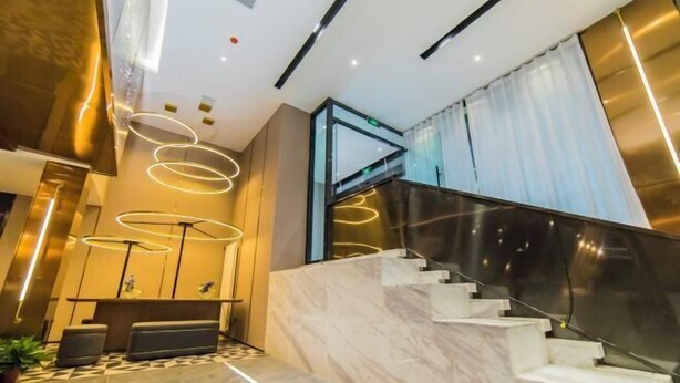 A modern lobby with a marble staircase, a reception desk, and a glass elevator. - Homeinn Plus Hotel (Qingdao Weihai Road Taidong Pedestrian Street) (Qingdao)
