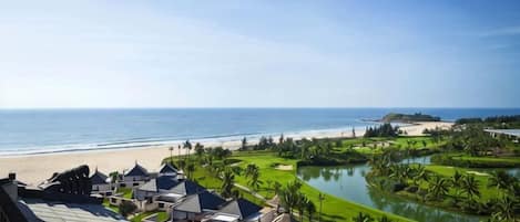Un resort con villas frente a la playa, un campo de golf y una extensión de agua.