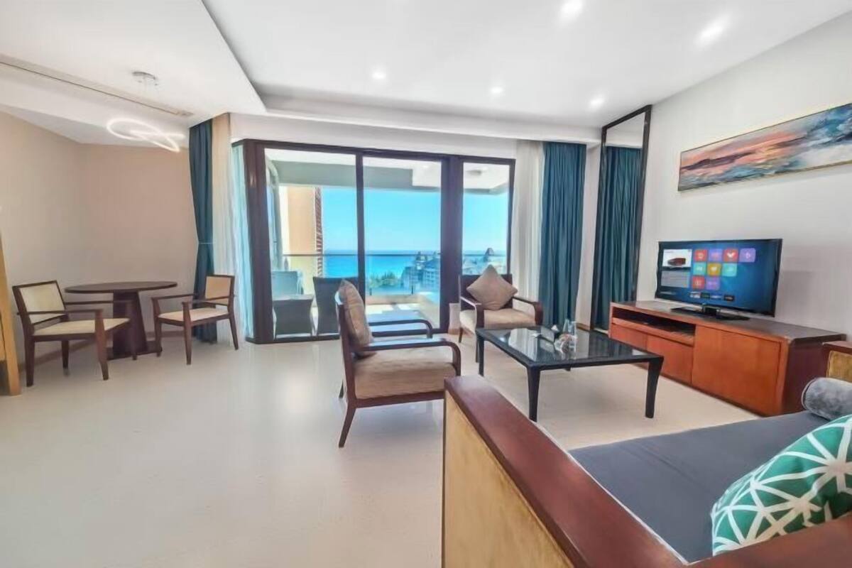 A modern living room with a balcony, a television, and a dining area.