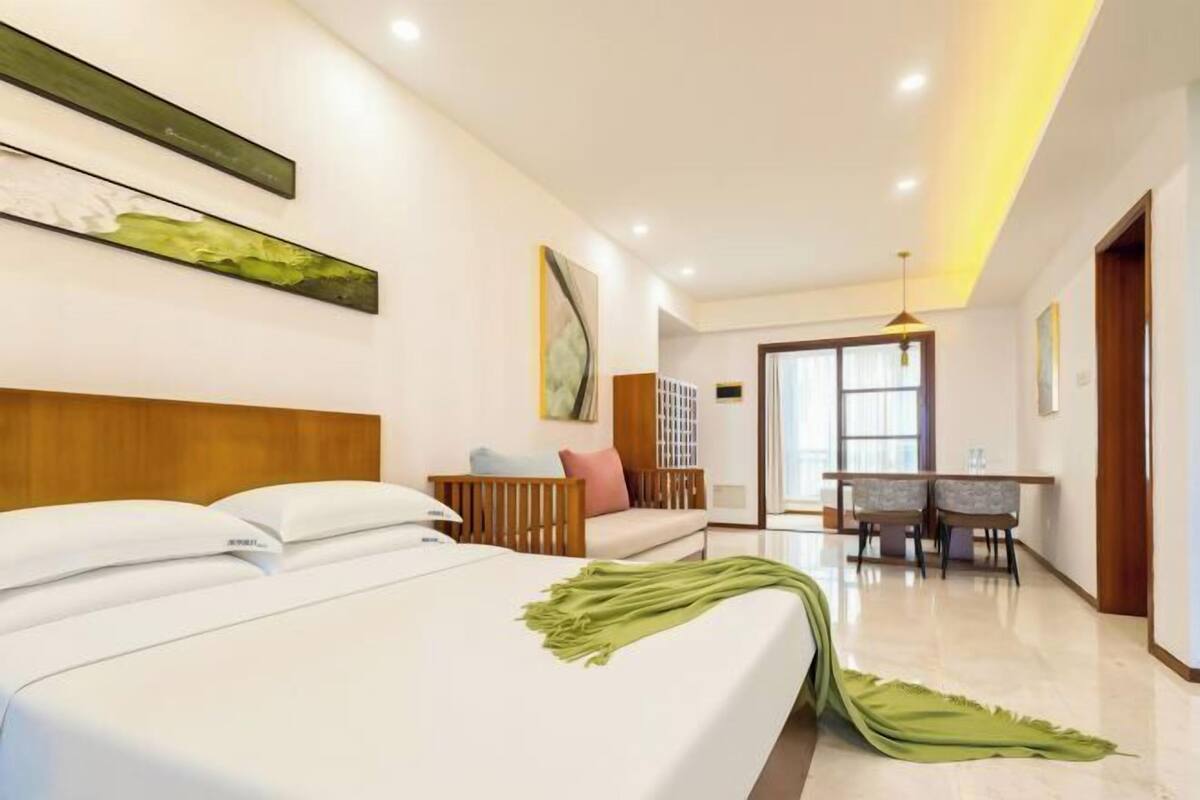 A hotel room with a bed, a desk, and a chair.