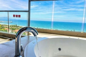 Un baño con lavamanos y vista al océano.