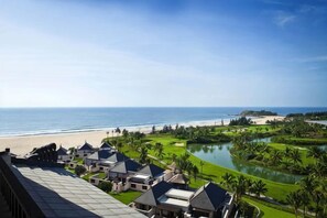 Un resort con vistas a la playa, un campo de golf y una masa de agua.