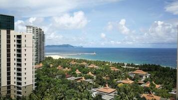 A coastal residential area with high-rise buildings, beachfront, and lush greenery.