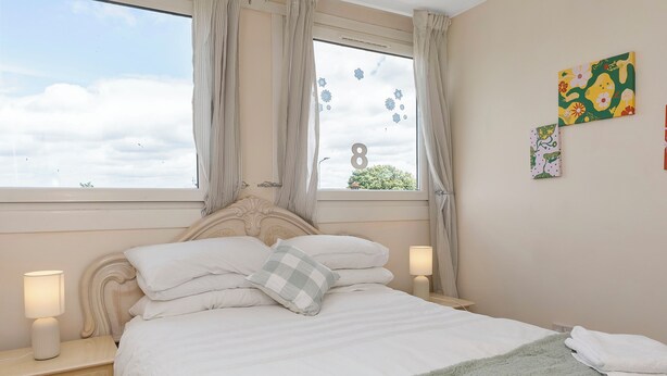 A bedroom with a bed, nightstands, a window with curtains, and wall art. - Room-edinburgh Bungalow Royal Infirmary (Edinburgh)