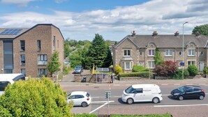 A residential street with houses, a bus stop, and parked cars. - Room-edinburgh Bungalow Royal Infirmary (Edinburgh)
