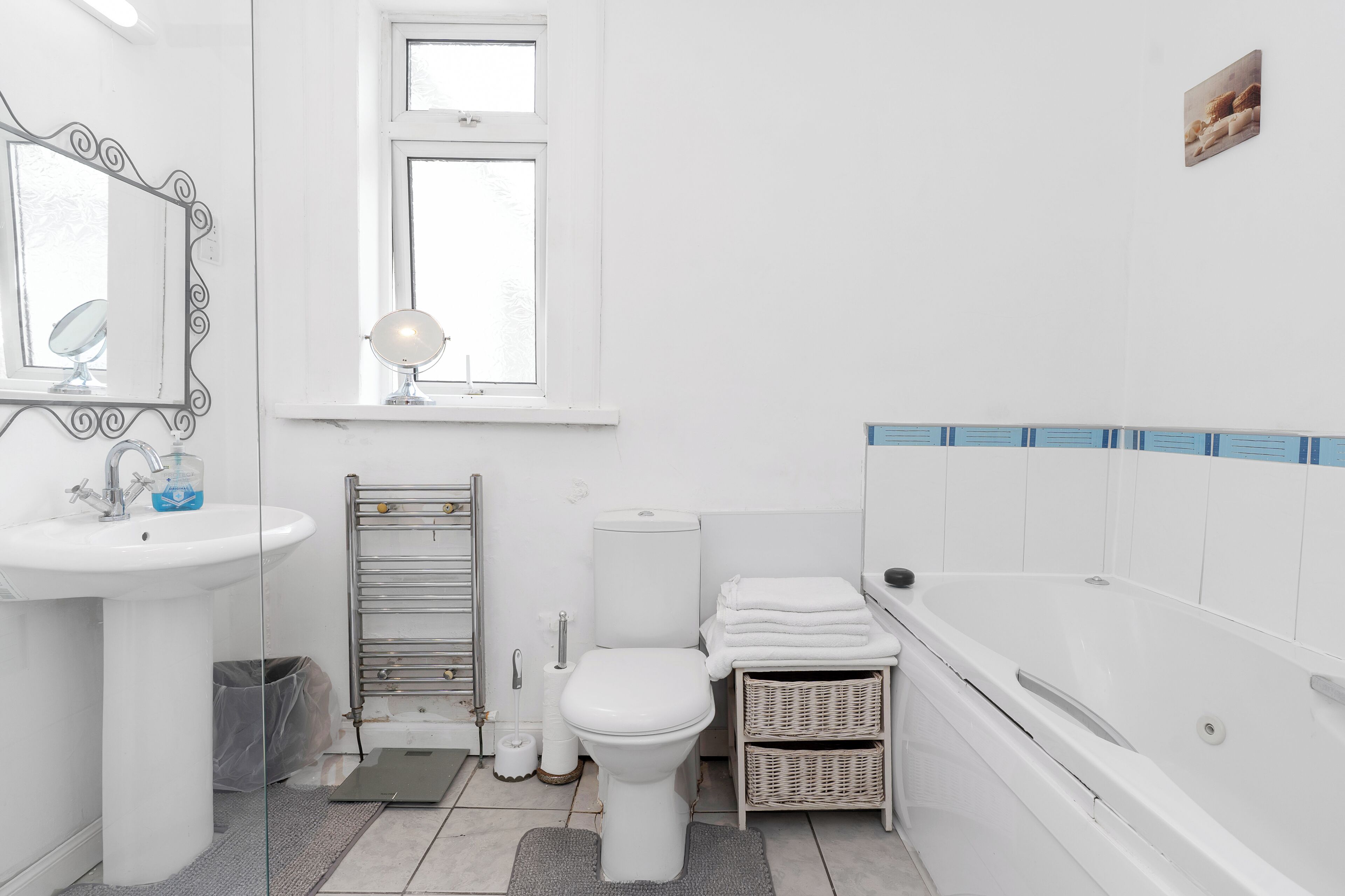 A bathroom with a sink, mirror, toilet, and bathtub.