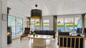 Un salón espacioso con chimenea, una mesa de centro de madera grande y un mobiliario cómodo.
