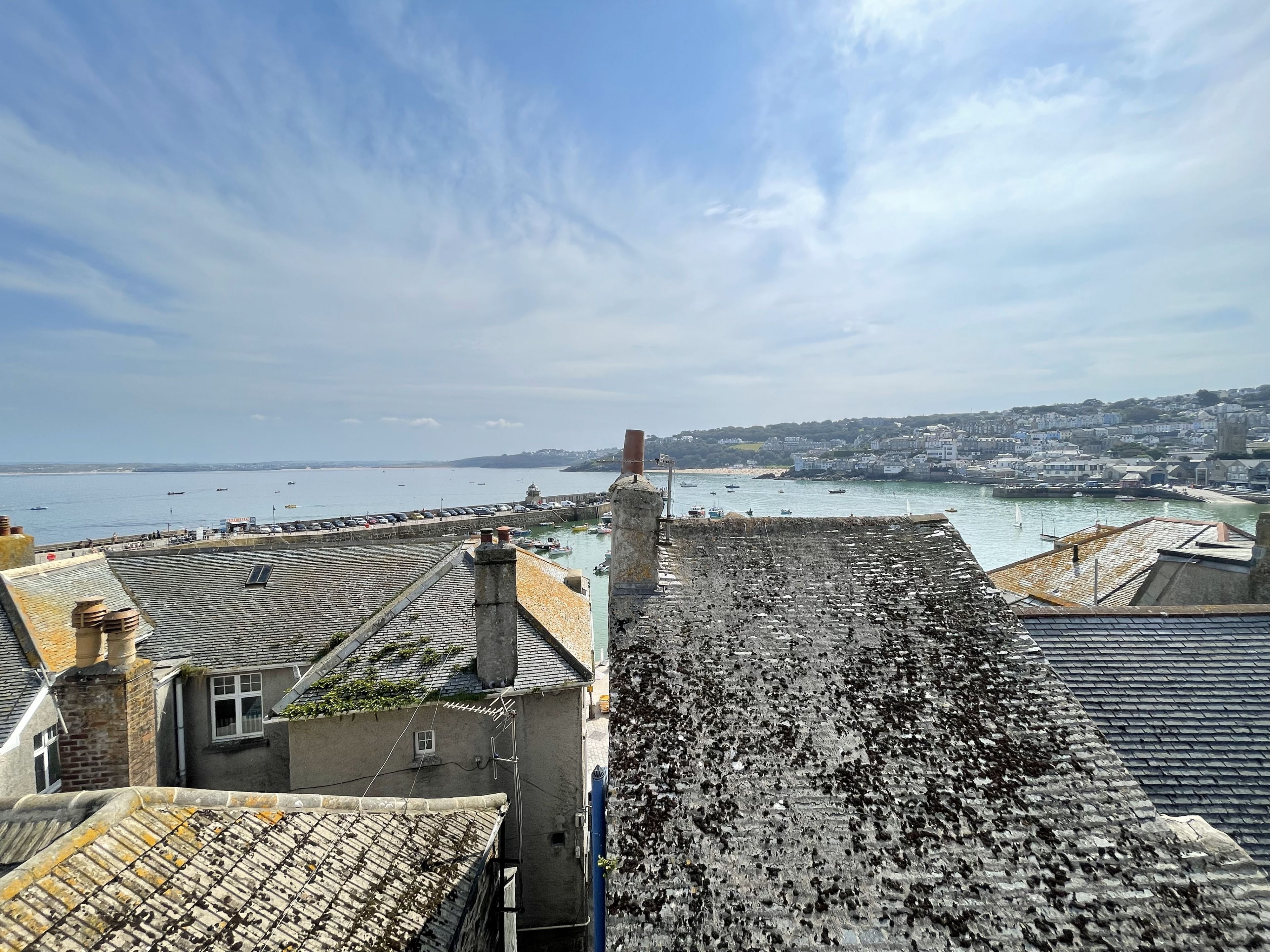 Un borgo costiero con edifici in pietra, un porto e imbarcazioni.