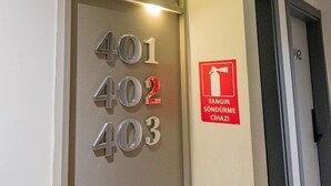 Ein Hotelinnenraum mit einer Wand, auf der die Zimmernummern 401, 402, 403 und 404 angebracht sind, sowie ein Brandschutznachweis.
