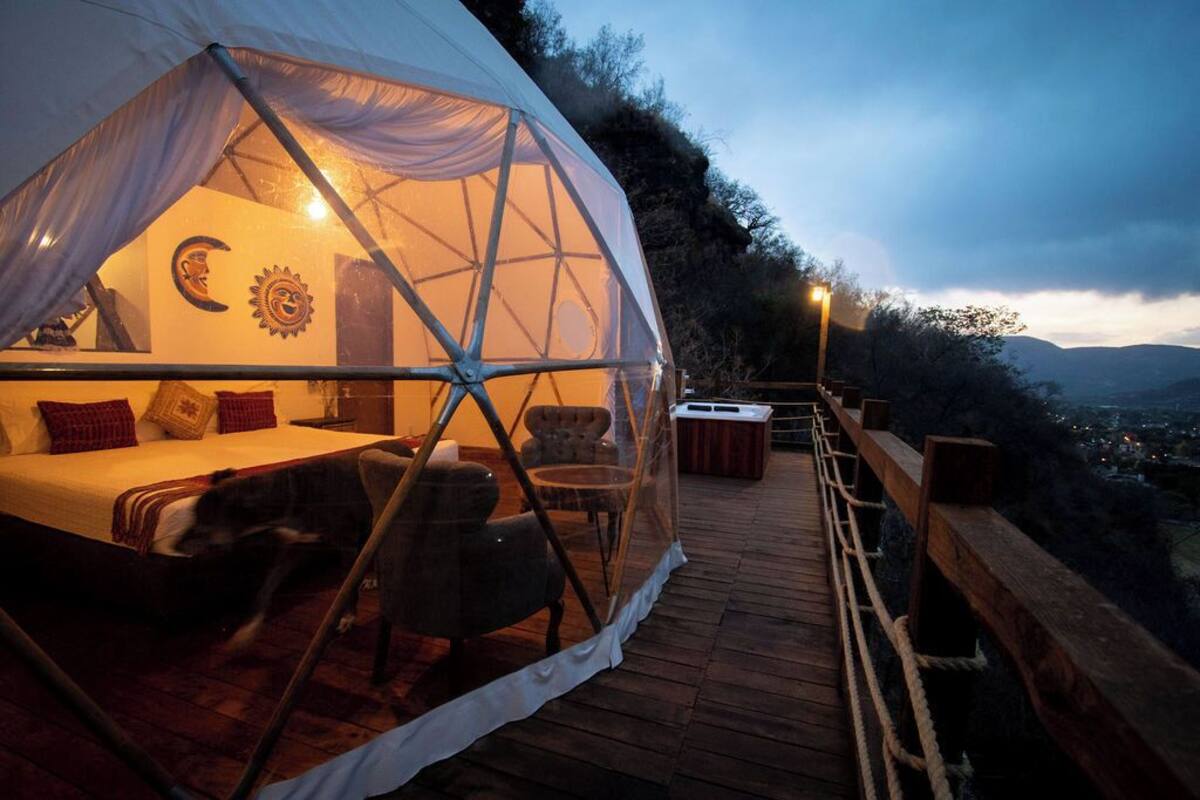 Un alojamiento en tienda de campaña acogedor con cama, zona de estar y vistas al paisaje.