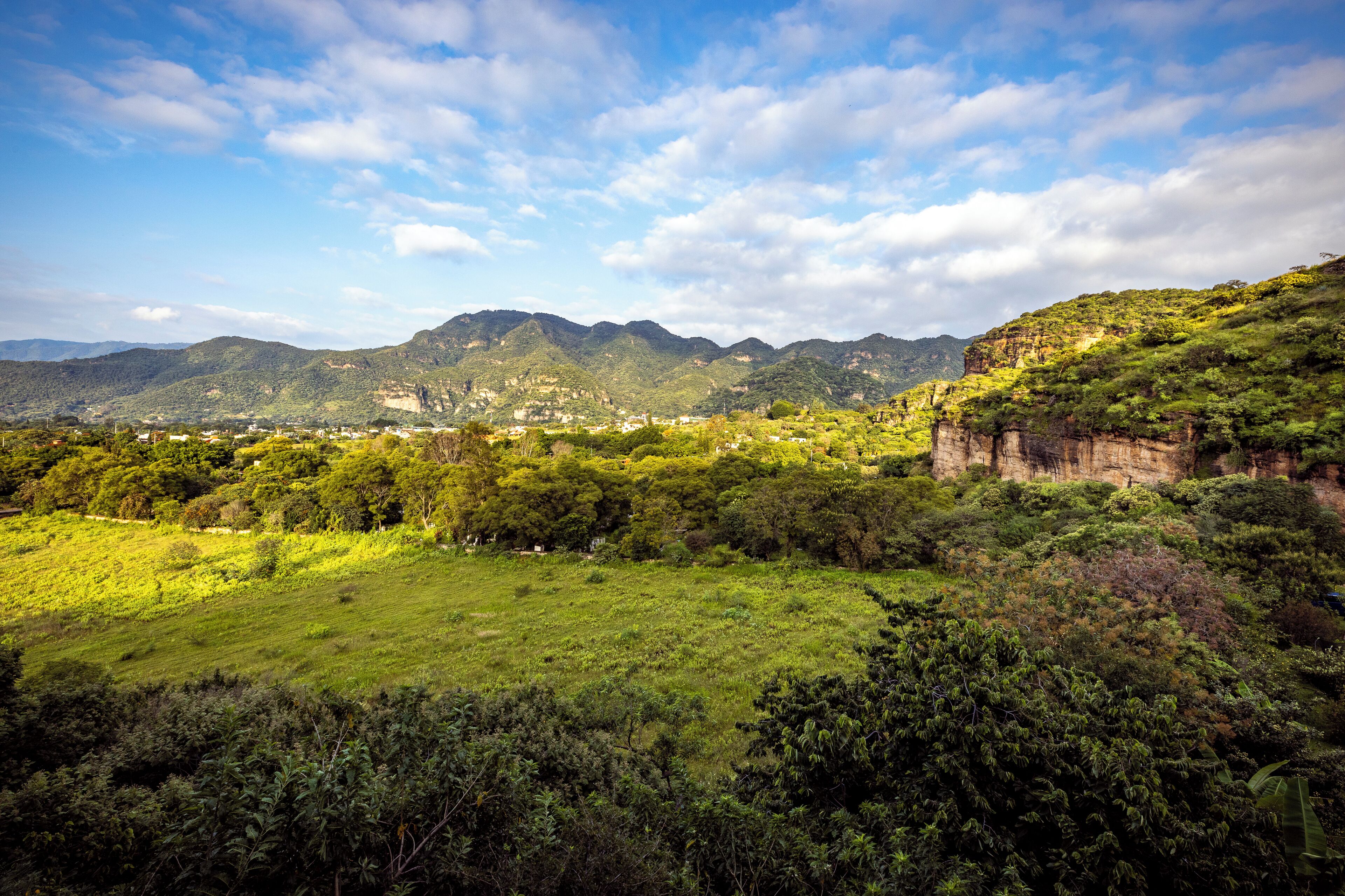 A panoramic view of a mountainous landscape with lush greenery and a clear sky.