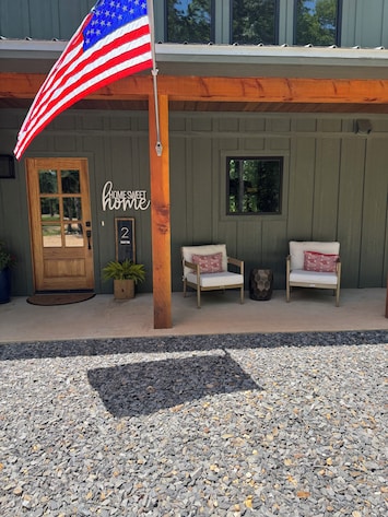 Welcoming front porch with cozy chairs and American Flag for the small-town feel