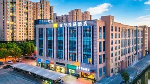 A modern hotel building with a prominent glass facade, multiple floors, and a covered entrance area. - No.1 Boutique Hotel (Changshu Qinhu Branch) (Changshu)