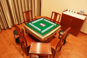 A pool table with four chairs, a small table, and a cabinet with bottles. - No.1 Boutique Hotel (Changshu Qinhu Branch) (Changshu)