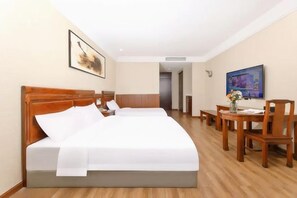 Una habitación de hotel con una cama grande, un escritorio con una silla, un televisor y un cuadro en la pared.
