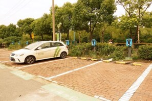A parking area with a white car parked near a charging station. - No.1 Boutique Hotel (Changshu Qinhu Branch) (Changshu)