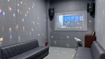 A room with a projection screen, two couches, and a small table.