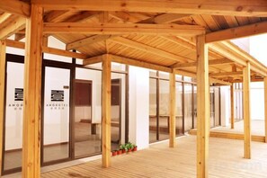 A hotel interior with wooden beams, glass doors, and a tiled floor. - No.1 Boutique Hotel (Changshu Qinhu Branch) (Changshu)