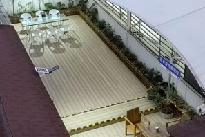 A rooftop terrace with a seating area, potted plants, and a clear sky. - No.1 Boutique Hotel (Changshu Qinhu Branch) (Changshu)
