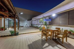 An outdoor patio area with wooden flooring, a table and chairs, and potted plants. - No.1 Boutique Hotel (Changshu Qinhu Branch) (Changshu)