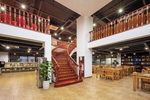 A spacious interior with a central spiral staircase, high ceilings, and a mezzanine level with bookshelves. - No.1 Boutique Hotel (Changshu Qinhu Branch) (Changshu)