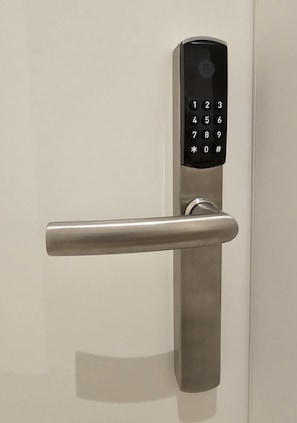 A modern door with a numeric keypad and a sleek handle.