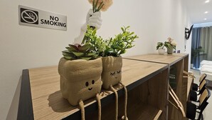 A reception desk with a 'No Smoking' sign, two decorative planters with plants, and a modern interior design. - Aparthotel Rahl (Hamburg)