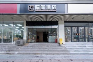A hotel entrance with a modern design, featuring a large glass facade, a staircase leading up to the entrance, and a sign above the door. - JiTing Inn (Shanghai XinhuaTongJingHospital) (Shanghai)