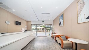 A modern reception area with a counter, seating, and artwork on the walls.
