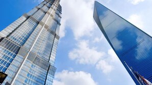 Two high-rise buildings with reflective glass facades and a clear sky.