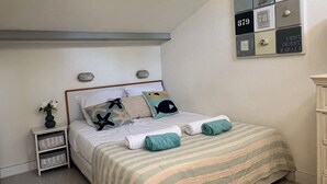 A bedroom with a bed, a nightstand, a wall-mounted light, and a small shelf. - 4/6 person apartment with sea view- Gigaro beach within walking distance- La Croix-Valmer-Pool (La Croix-Valmer)