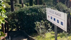 Señalización que indica 'Accès Plage' con símbolos que muestran servicios como estacionamiento y zona de picnic.