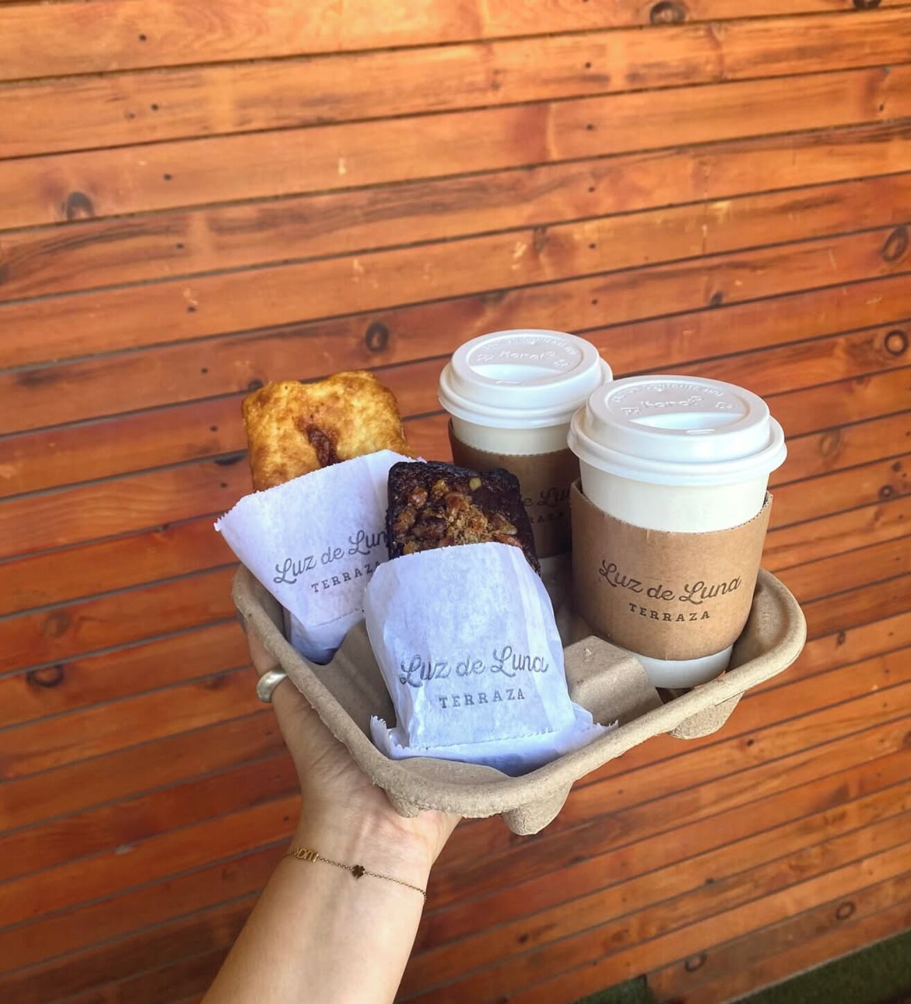 Una bandeja con un pastel, dos tazas de café y una servilleta con texto.