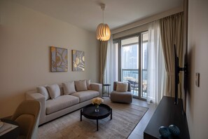 Un salon moderne avec un canapé, un fauteuil, une table basse et des œuvres d’art accrochées au mur.