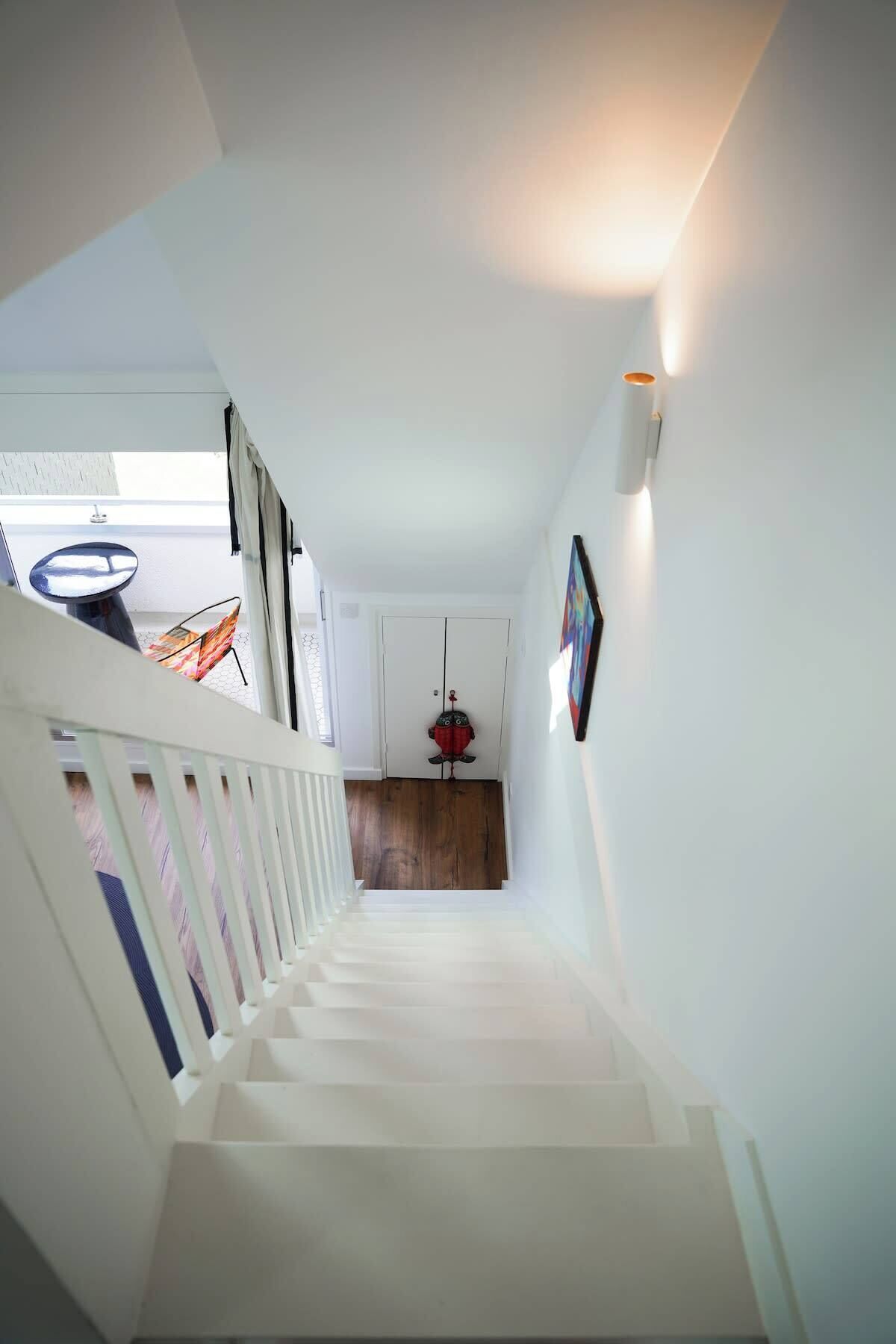 Una escalera moderna con barandillas blancas que conduce a una plataforma.