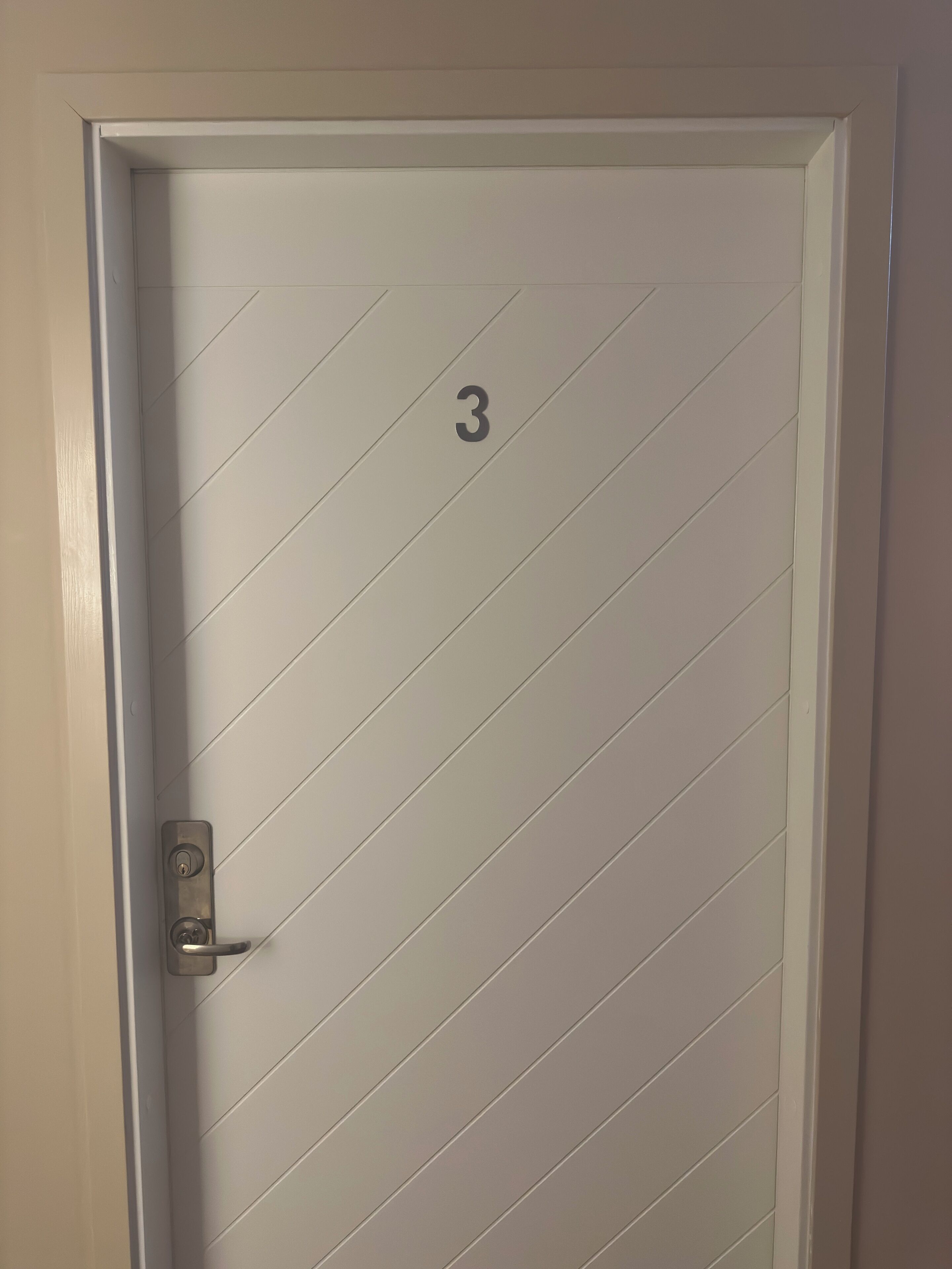 A white door with a number '3' and a keyhole.