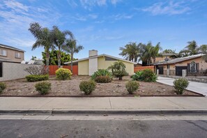 A residential house with a front yard, palm trees, and a driveway. - Disney Themed 4-bedroom house w/ pool ~10 min away from Disneyland (Anaheim)
