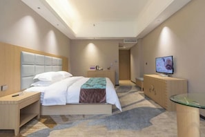 Una habitación de hotel con cama, mesita de noche, televisor y una mesa de vidrio.