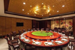 A conference room with a round table, chairs, and a television screen. - Dinis Hotel (Luoyang Kaiyuan) (Luoyang)