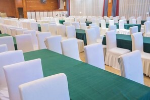 A conference room with rows of white chairs and green tablecloths. - Dinis Hotel (Luoyang Kaiyuan) (Luoyang)