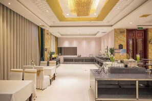 A hotel lobby with a reception desk, seating area, and a large chandelier. - Dinis Hotel (Luoyang Kaiyuan) (Luoyang)