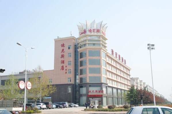 A multi-story hotel with a prominent sign at the top, a parking lot in front, and a clear sky. - Dinis Hotel (Luoyang Kaiyuan) (Luoyang)
