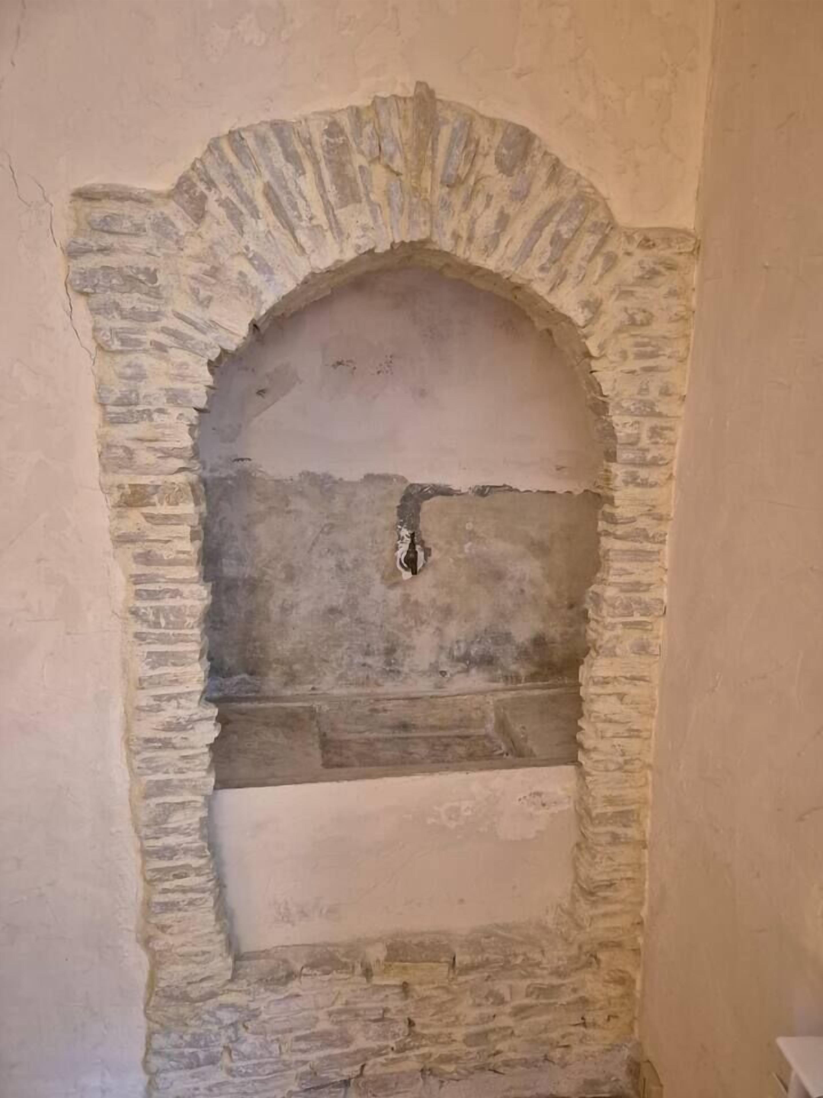A stone archway with a rough, unfinished surface.