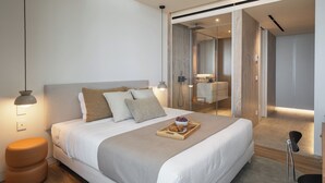 A modern bedroom with a large bed, bedside lamps, a wooden bedside table, and a tray with snacks. - Savoy Monumentalis IV – Luxury and Unmatched Views (Funchal)