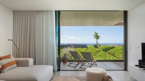 A modern bedroom with a large sliding glass door leading to a balcony with a view of the ocean and greenery. - Savoy Monumentalis IV – Luxury and Unmatched Views (Funchal)