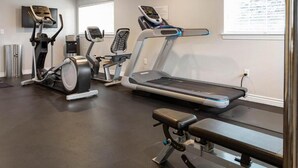 A gym with treadmills, elliptical machines, and a bench press. - Charming 2-bedroom resort in lovely Midway with gym, indoor pool and more. (Midway)