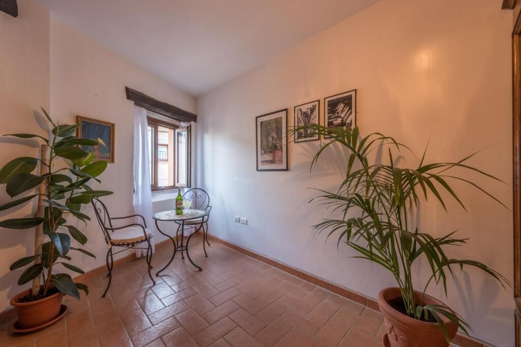 Ein Flur mit Essbereich, Zimmerpflanzen und gerahmten Bildern an der Wand.